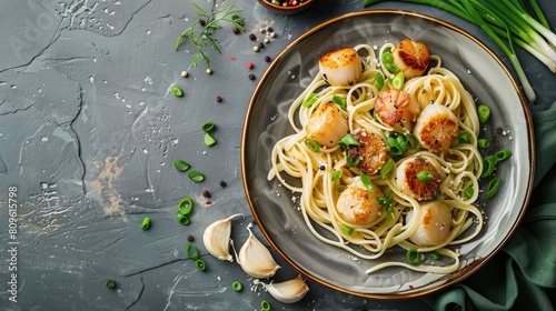 Tasty scallop pasta with green onion on a gray tabletop overhead shot Room for text