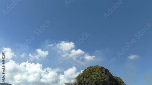 Tilt down reveal of the karst limestone cliff face at Ille Cave in El Nido. photo