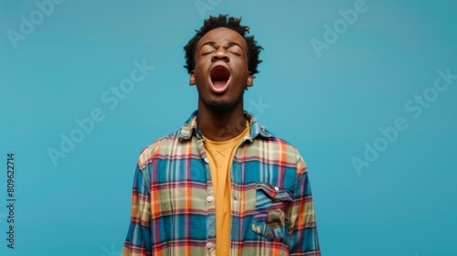 Man Yawning on Blue Background photo