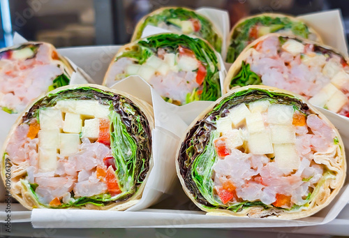 Lavash rolls with fresh lettuce and chicken fillet with sauce close-up. Quick snack concept.