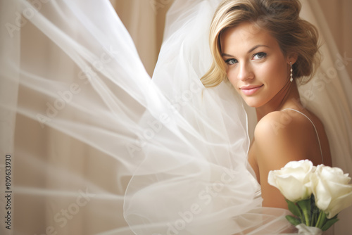 A woman in a wedding dress is posing for a picture with a bouquet of white roses