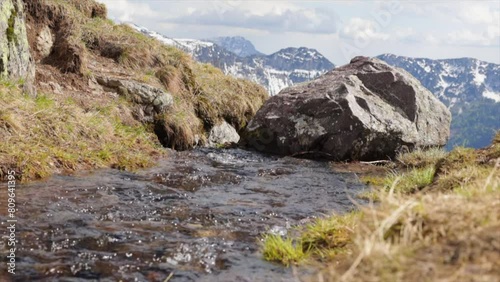 ripresa in tempo reale con visuale in primo piano che mostra l'acqua limpida che scorre lungo un ruscello di montagna photo