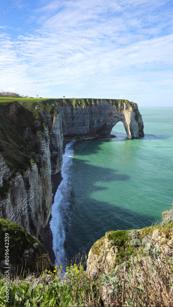 Cliffs, landscape along the Falaise d'Aval, view of the La Manche. Etretat, Normandy, France, English Channel. Natural rocks, coast. Rocks of the village of Etretat in spring in cloudy weather Cliffs, landscape along the Falaise d'Aval, view of the La Manche. Etretat, Normandy, France, English Channel. Natural rocks, coast. Rocks of the village of Etretat in spring in cloudy weather