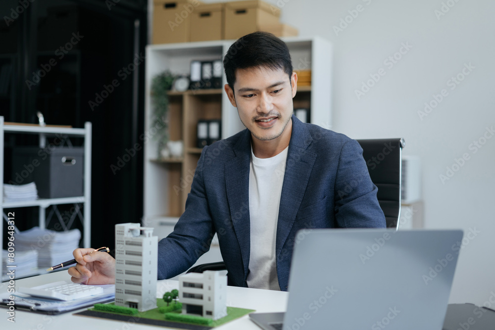 home loan officer uses a calculator with a house plan loan real estate or property. home loan officer uses a calculator with a house plan loan real estate or property.