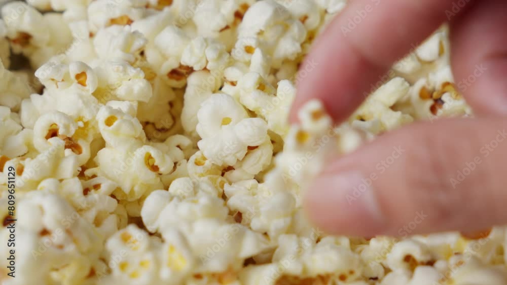 Person picking popcorn and showing to camera. Close up Person picking popcorn and showing to camera. Close up