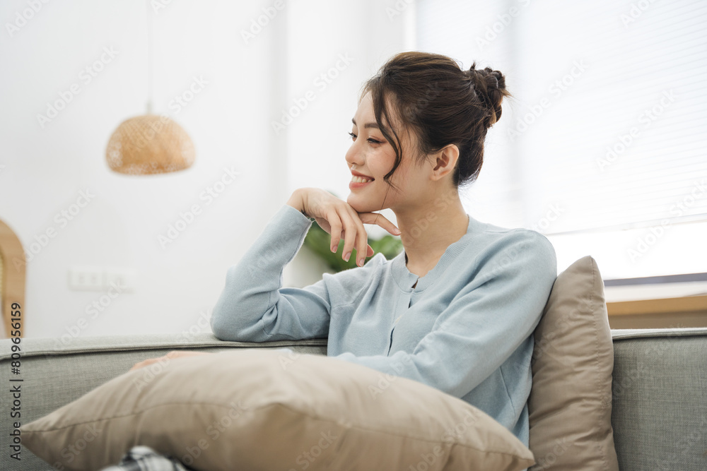 Portrait of Asian woman sitting on sofa at home Portrait of Asian woman sitting on sofa at home