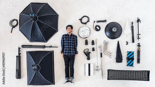 Aerial top view or flat lay Asian photographer with many photography equipment and professional studio photo shooting tool lying on white floor background use for header or banner of camera concept. photo
