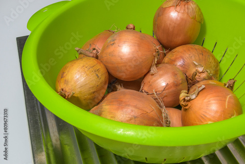 Regular onions close-up in a green bowl photo