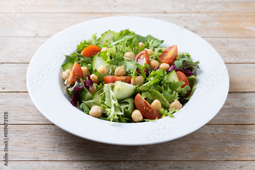 Healthy chickpea salad with tomato,lettuce and cucumber on wooden table