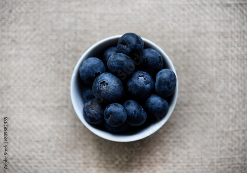 Blueberries in a white bowl on a burlap tablecloth. Juicy blueberries.