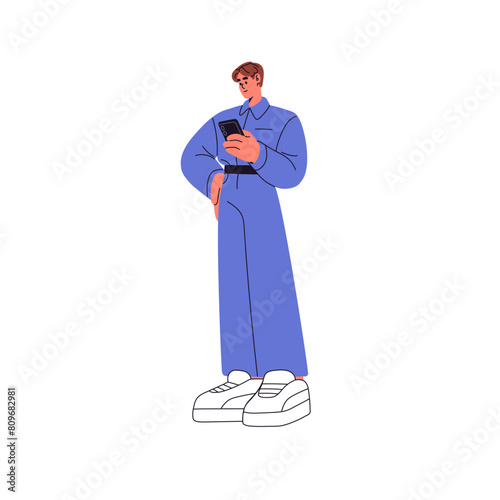Young person stands, holds mobile phone in hand, surfing internet. Character communicates in social networks, typing in smartphone. Online chat in telephone. Flat isolated vector illustration on white