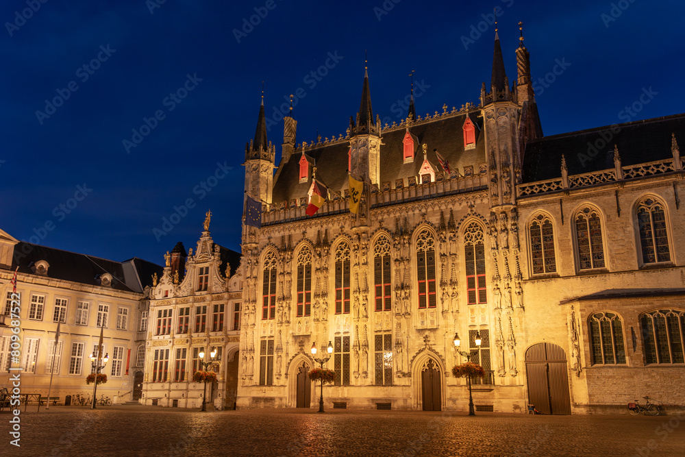 De Burg square and the city hall of the beautiful city of Bruges in Belgium at night, with its historic facades.