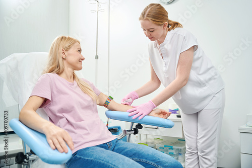 High-qualified nurse going to take the blood sample with vacutainer