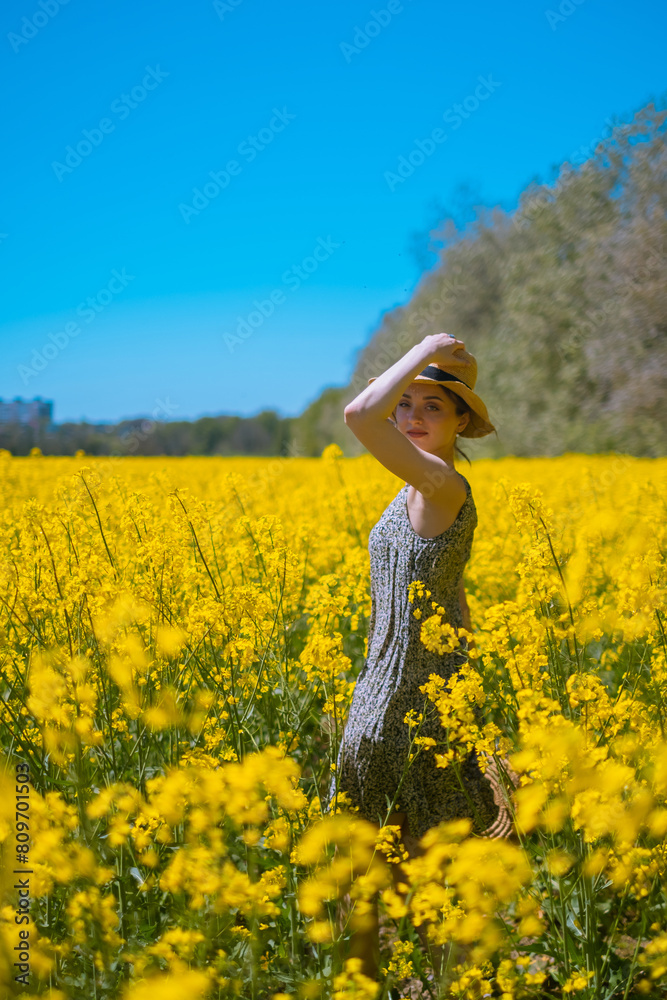 Brunette girl standing in blooming yellow field, enjoying natural beauty, plant material production, flower bloom and scent for perfume making. Brunette girl standing in blooming yellow field, enjoying natural beauty, plant material production, flower bloom and scent for perfume making.