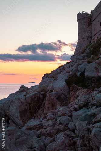 Couché de soleil sur la mer avec des rochers et remparts en avant plan, Dubrovnik