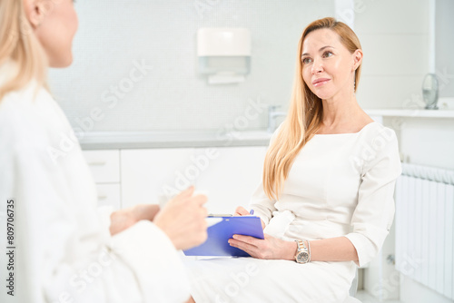 Attractive general practitioner attentively listening to her female patient
