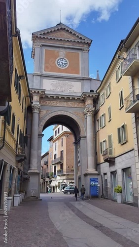Chieri, metropolitan city of Turin, Piedmont, Italy. April 21, 2024. Vertical format footage with the triumphal arch highlighted. The pan movement highlights the houses that join the arch. People. photo