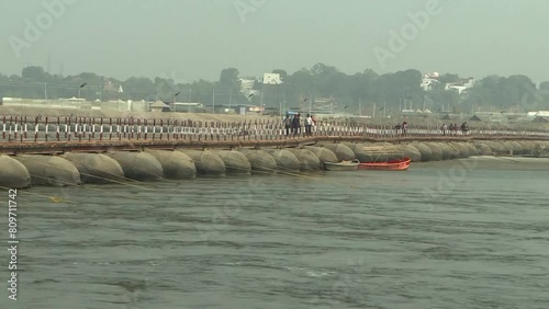 Pontoon bridge of Kumbh Mela known as floating bridge uses floats to support a continuous deck for pedestrian and vehicle travel. Thousands of Hindu devotees crossing the pontoon bridges over the Gang