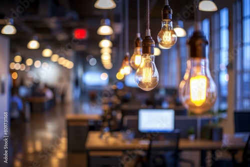 Modern office space with rows of hanging light bulbs casting warm illumination