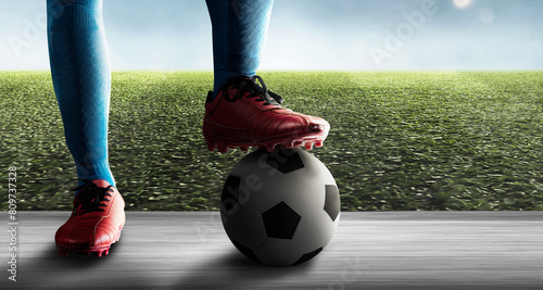 Closeup view of a male football player standing with the ball in the stadium hallway before entering the pitch