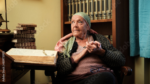 Foto scattata ad una nonna con a fianco una raccolta di libri antichi.