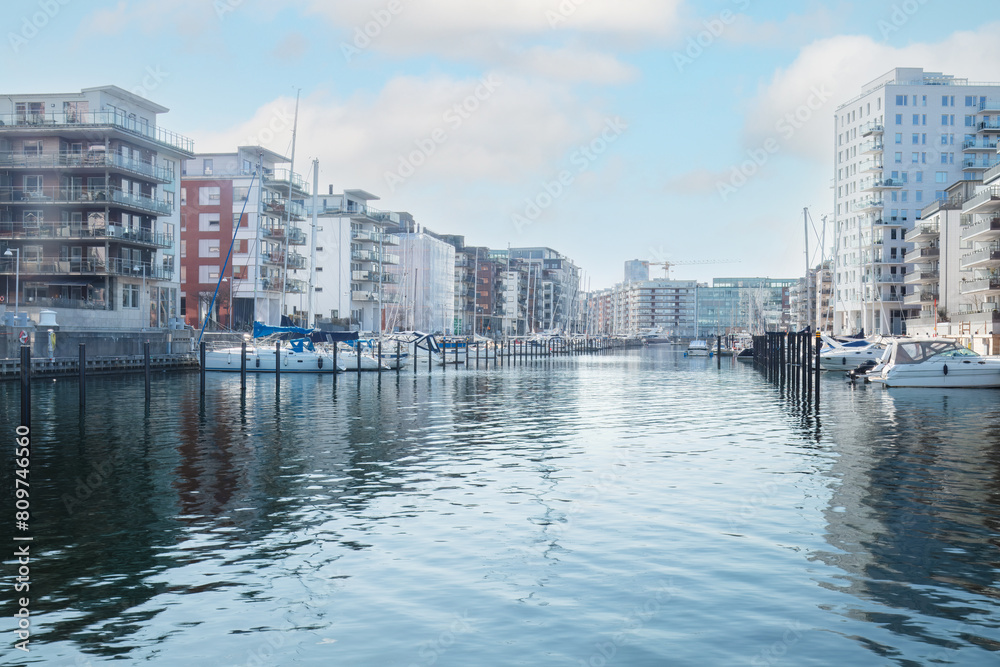 Fototapeta premium Cityscape at a Dockan Marina in Malmö, where boats dock in calm waters . Concepts: urban expansion, waterfront living, Malmö