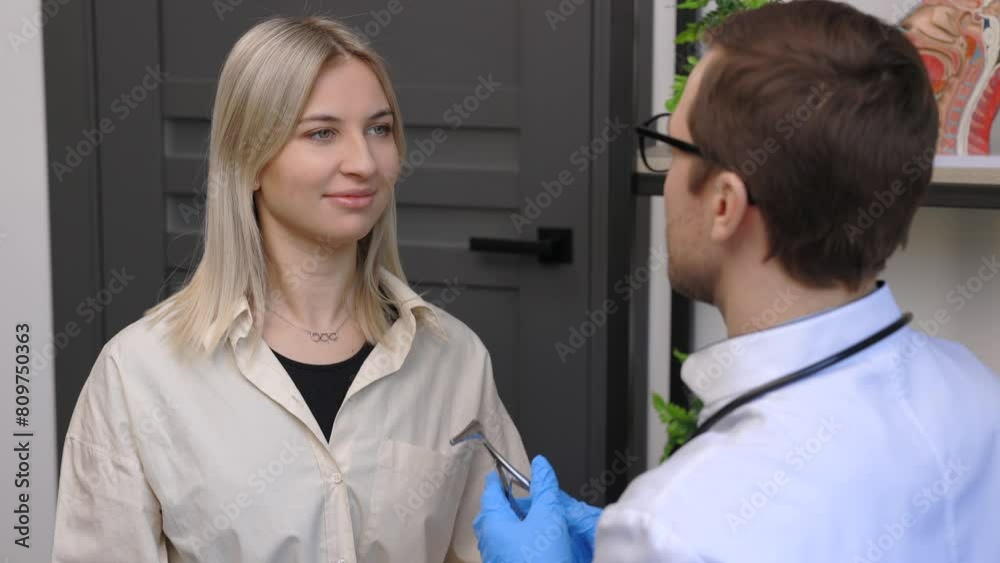 A young attractive otolaryngologist examining nose of a young patient during a medical examination in the ENT office A young attractive otolaryngologist examining nose of a young patient during a medical examination in the ENT office