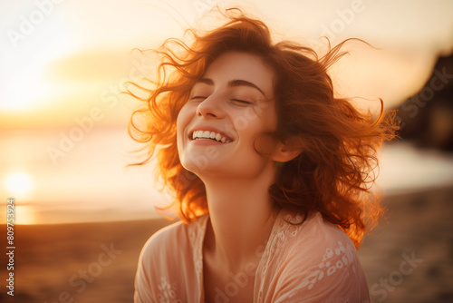 Portrait of calm happy smiling free woman with closed eyes enjoys a beautiful moment life on the beach at sunset. vacations time. travel concept #809753924