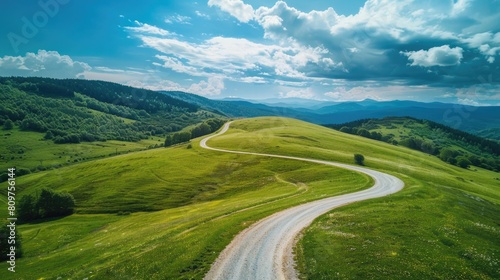 A winding road cuts through a lush green field