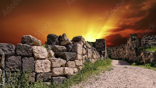 Roman ruins at Umm Qais (Umm Qays)--is a town in northern Jordan near the site of the ancient town of Gadara, Jordan. Against the background of the sunset, 4K, time lapse, with zoom   photo