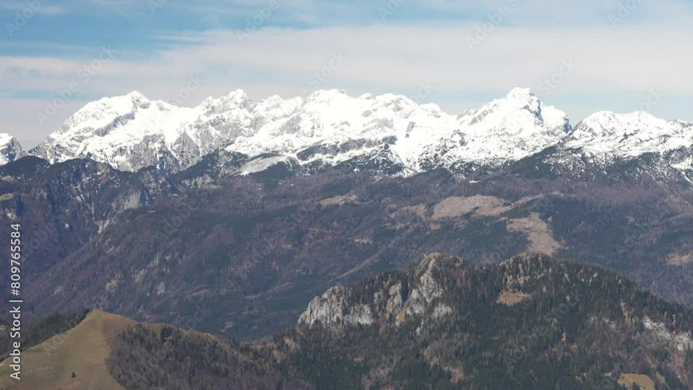 View of Austrian mountains from plane window. Scenic flight above Alps in spring
