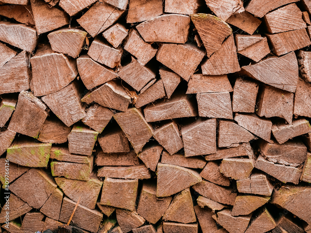 Stack of chopped firewood. Cheap budget heating material. Light brown wood color. Home comfort concept. Winter cold season preparation concept. Stack of chopped firewood. Cheap budget heating material. Light brown wood color. Home comfort concept. Winter cold season preparation concept.