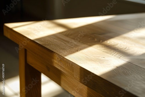 Close up of a wooden table with sunlight streaming through a window