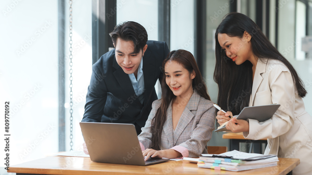 Group of young Asian business people brainstorming, looking at laptop computer. Group of young Asian business people brainstorming, looking at laptop computer.