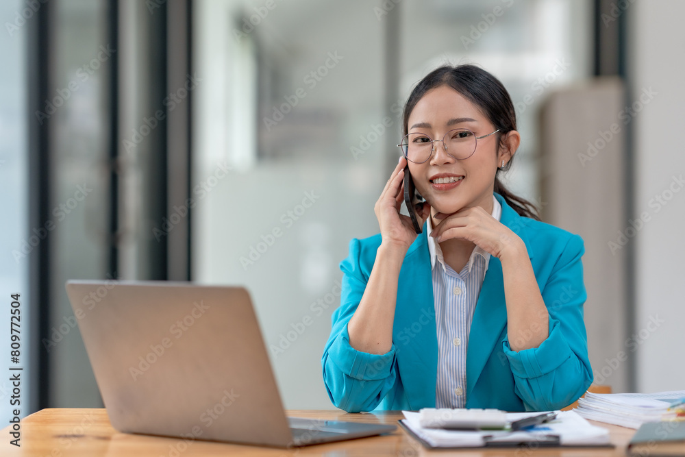 Asian businesswoman modern professional talking with client on the phone with a confident demeanor and effective communication skill. business, marketing, sale and communication project. Asian businesswoman modern professional talking with client on the phone with a confident demeanor and effective communication skill. business, marketing, sale and communication project.