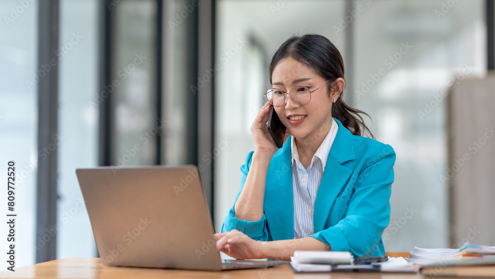 Asian businesswoman modern professional talking with client on the phone with a confident demeanor and effective communication skill. business, marketing, sale and communication project. Asian businesswoman modern professional talking with client on the phone with a confident demeanor and effective communication skill. business, marketing, sale and communication project.