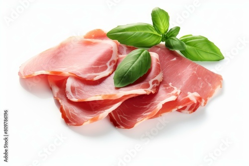 Slices of prosciutto with fresh green basil leaves isolated on a white background