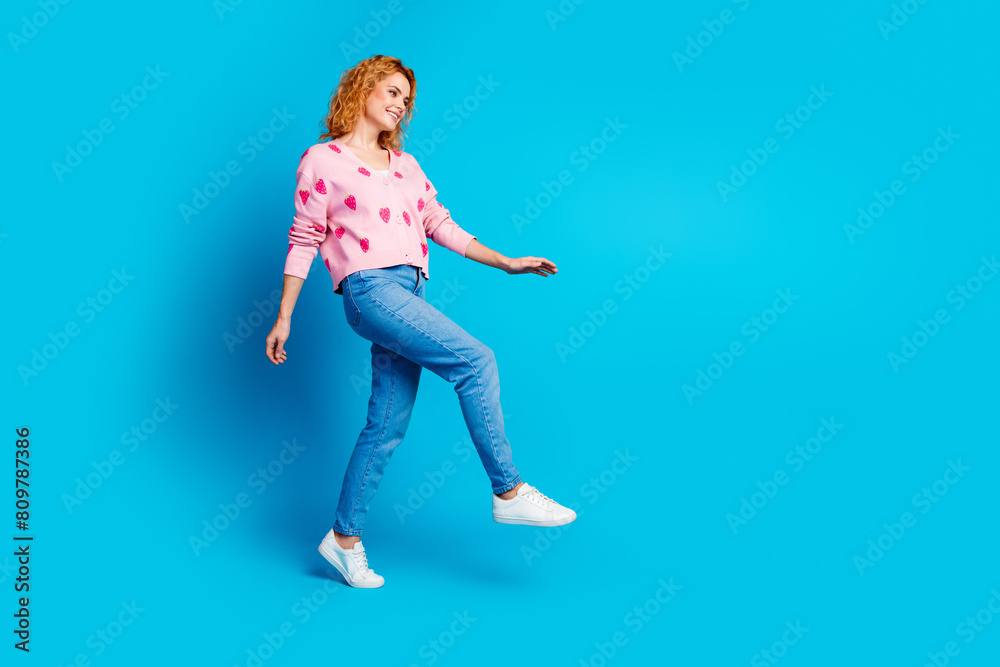 Full length photo of attractive young woman model walking dressed stylish pink clothes isolated on blue color background Full length photo of attractive young woman model walking dressed stylish pink clothes isolated on blue color background