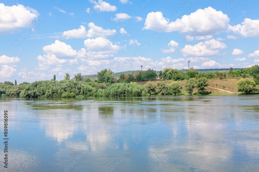 Landscape with river and blue sky with white clouds on summer day