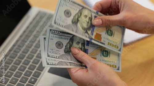 Caucasian Businesswoman counting a lot of money in front of the computer after a working day. , close up, hands, fingers, money.