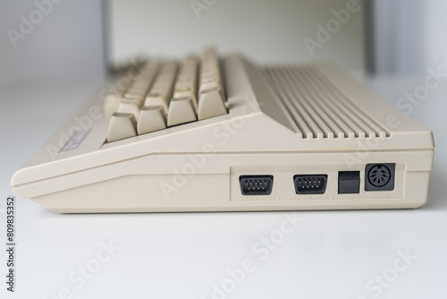 A side view of a vintage computer with visible ports, illuminated by daylight. Perfect for illustrating computer hardware, technology concepts, and connectivity.