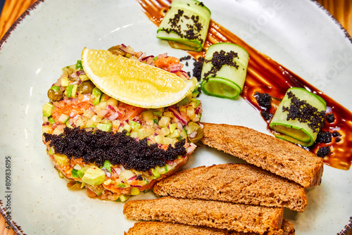 Salmon tartare with red onion, avocado, capers and black bread croutons