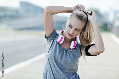 Active young woman working out with headphones outside