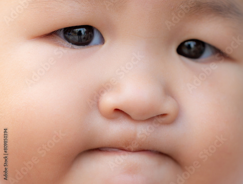 Close-up of child's face,Portrait of a sad focused baby. Closed baby's eyes. Beautiful eyes, deep black watercolor. Child, baby, people, healthcare, psychology, curiosity, sadness, feelings.