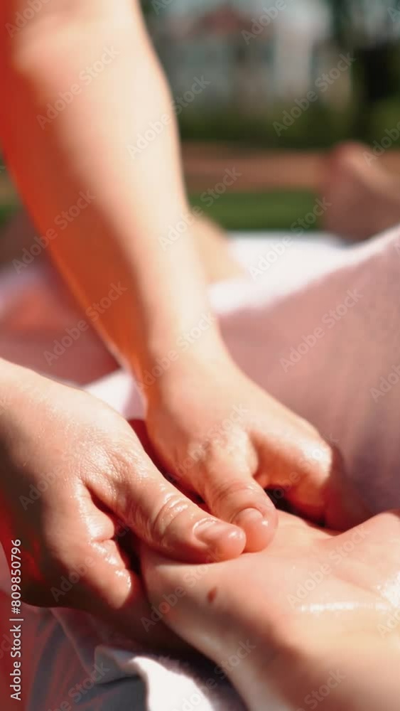 A master masseur in a bright orange uniform gives a healing body massage to a handsome man with muscles. Sports, recreation, health, relaxation and self-care in the summer outdoors A master masseur in a bright orange uniform gives a healing body massage to a handsome man with muscles. Sports, recreation, health, relaxation and self-care in the summer outdoors