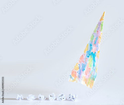 Fresh ideas for business transformation with crumpled paper  and a wild colored paper plane taking off, innovation,success, teamwork and creativity business concept