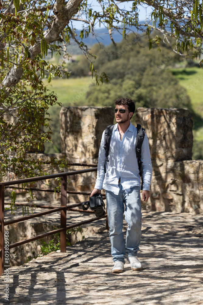 man walking through nature with his video camera. Man recording in nature with his video camera. Professional doing a video report in nature. Boy doing nature tourism, traveling with his camera. man walking through nature with his video camera. Man recording in nature with his video camera. Professional doing a video report in nature. Boy doing nature tourism, traveling with his camera.