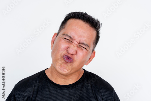 Middle-aged Asian man pouting and closing eyes in a playful kiss gesture, isolated on white photo