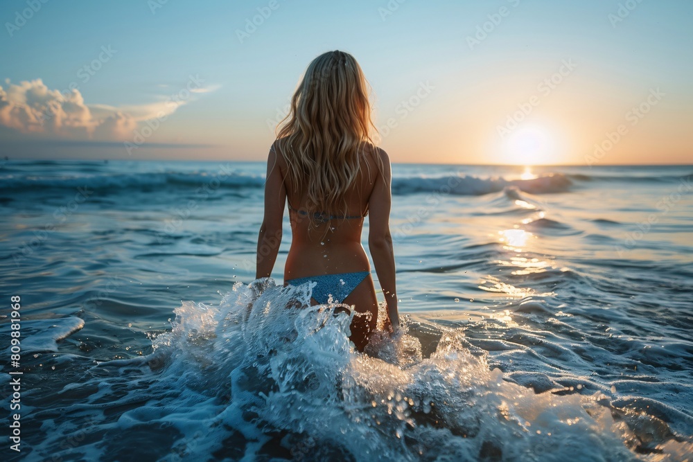 A bronzed blonde lady with a slender yet curvaceous figure, emerging from the ocean with confidence in a bikini