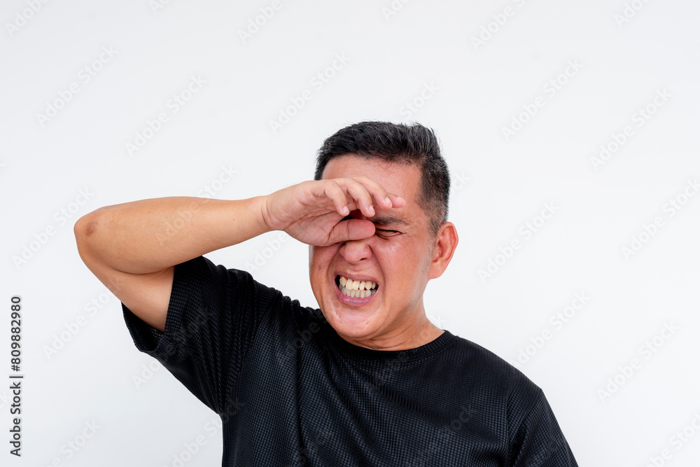 Middle aged Asian man rubbing irritated eyes, feeling discomfort, isolated on white Middle aged Asian man rubbing irritated eyes, feeling discomfort, isolated on white
